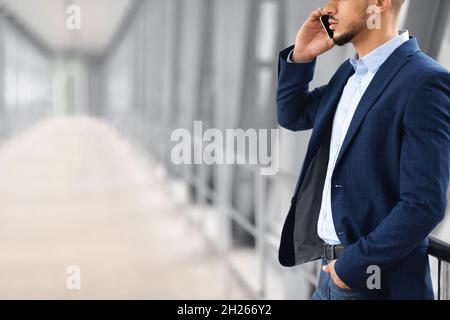 Mobile Call. Young Arab Businessman Talking On Cellphone At Airport Terminal Stock Photo