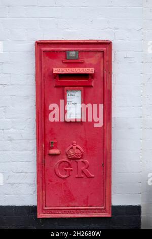 1910-1936  George V fifth wall mounted post box in white painted brick wall Stock Photo