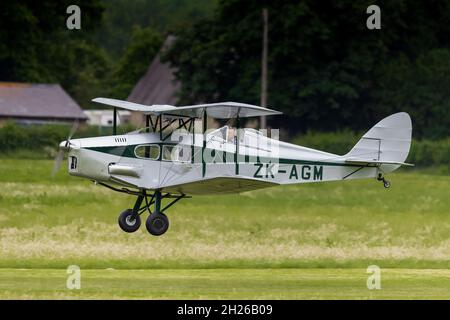 1938 de Havilland DH.83 Fox Moth ‘ZK-AGM’ airborne at the Shuttleworth Evening Airshow on the 19th June 2021 Stock Photo