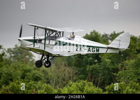 1938 de Havilland DH.83 Fox Moth ‘ZK-AGM’ airborne at the Shuttleworth Evening Airshow on the 19th June 2021 Stock Photo