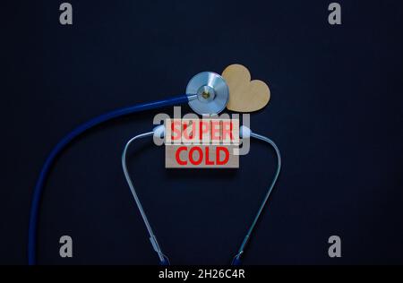 Super cold symbol. White card, words Super cold. Wooden heart and stethoscope. Beautiful black background. Medical, Covid-19 and super cold concept. Stock Photo