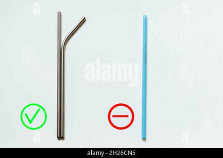 Reusable metal straws for drinks and disposable blue plastic straws. Stock Photo
