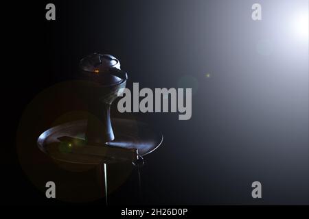 Hookah stands on a black background and a glare from the light shines on him.  Stock Photo