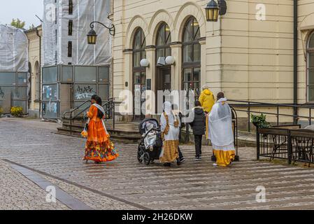 etnic group in long coloured skirts walking in front of the central station in Lund, Sweden, September 11, 2021 Stock Photo