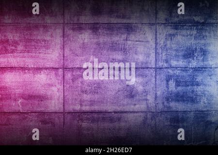 Black rough concrete wall background with neon lights and glowing lights. Lighting effect pink purple and blue on empty cement wall. Stock Photo