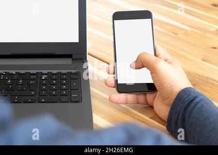 Man using laptop and smartphone. Screen mockup Stock Photo