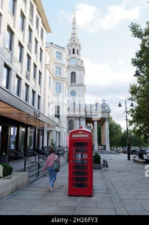 London, Greater London, England, October 05 2021: Red Phone box with St Martin in the Fields church behind near Trafalgar Square. Stock Photo