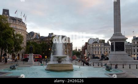 London, Greater London, England, October 05 2021: Fountain in Trafalgar Square with traffic and housing lights glow in the evening Stock Photo