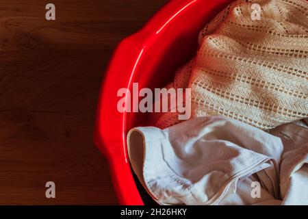 Red basin with linen on a wooden background.  Stock Photo