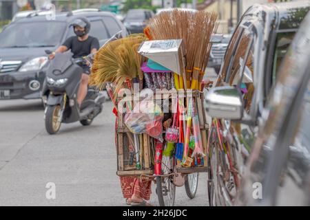 A woman who sells cleaning and household items uses a bicycle as a means of transportation. BOYOLALI, INDONESIA - OCTOBER 18, 2021. Stock Photo