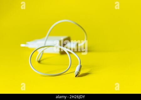 White charger with micro usb on a bright yellow background.  Stock Photo