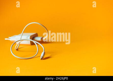 White charger with micro usb on a bright yellow background.  Stock Photo