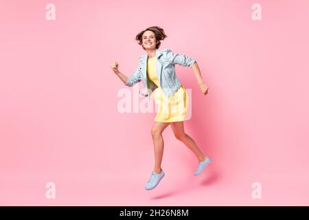 Full size profile side photo of young beautiful happy cheerful positive girl running in air isolated on pink color background Stock Photo