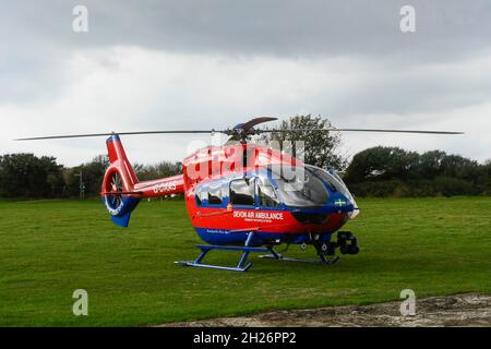 The Devon Air Ambulance helicopter in a field at Burton Bradstock in Dorset while its medics attend to a medical emergency close by.  Picture Credit: Stock Photo