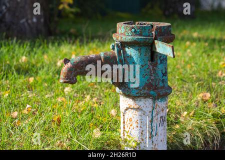 Old rusty water column in autumn, selective focus, blurred background Stock Photo