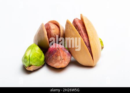 Macro shot of unshelled pile of pistachios on isolated white background. Stock Photo