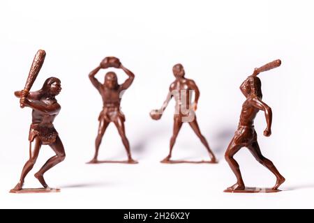 Large toy figures of primitive people on a white background Stock Photo