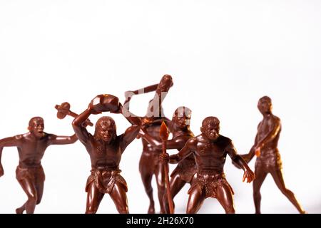 Large toy figures of primitive people on a white background Stock Photo