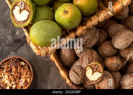 Hands openning newly collected fresh walnuts gathered together. Stock Photo