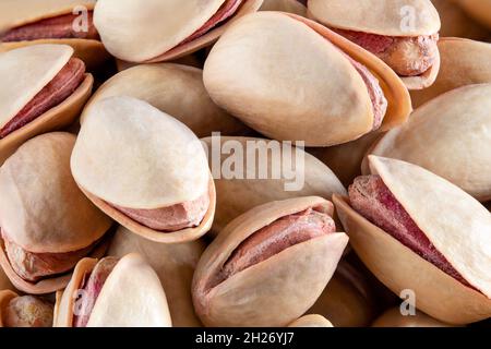 Macro shot of unshelled pile of pistachios on isolated white background. Stock Photo