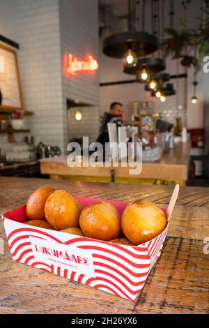 Popular snack food and store called Lukumades that makes fried dough balls covered in a variety of flavors on Aghias Irinis Street in Athens Stock Photo