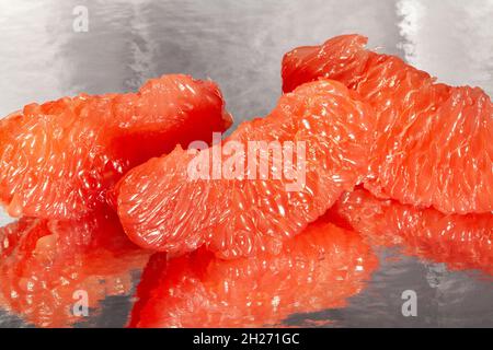sliced mirrored grapefruit on black background Stock Photo
