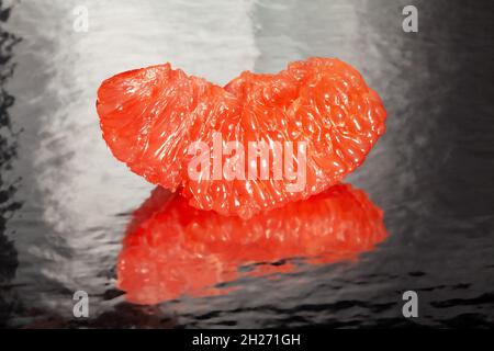 sliced mirrored grapefruit on black background Stock Photo