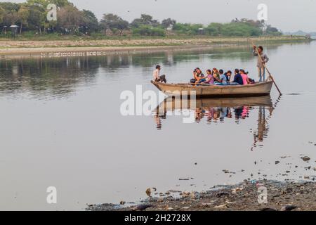 AGRA, INDIA - FEBRUARY 19, 2017: Tourists on a boat on Yamuna river observing Taj Mahal in Agra, India Stock Photo