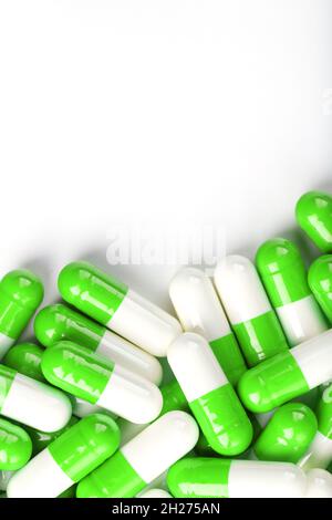 White and green pills on a white background. Top view Stock Photo