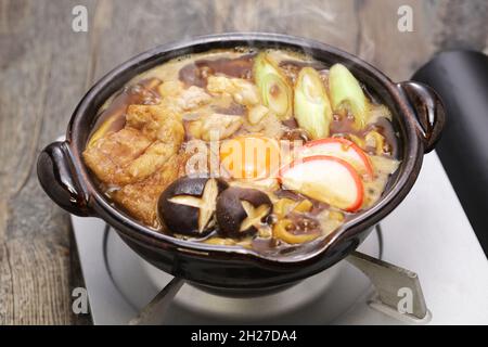 Miso Nikomi Udon is Japanese noodle hotpot dish cooked in miso broth. and that is very popular in Nagoya area. Ingredients are chicken, shiitake mushr Stock Photo