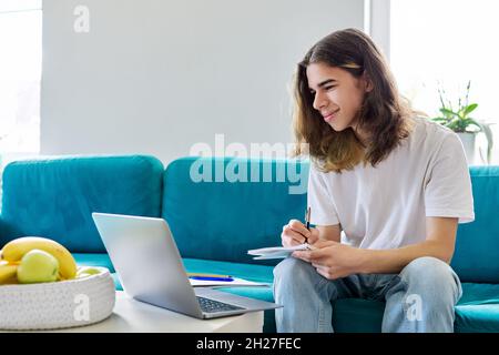 Guy student teenager studies at home online with a laptop Stock Photo