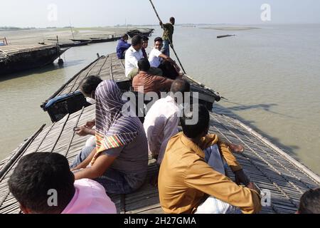 Bangladesh – September 24, 2021: Locals are traveling on the canopy of passenger boats in the rural village area at Rawmari, Kurigram, Bangladesh. Stock Photo