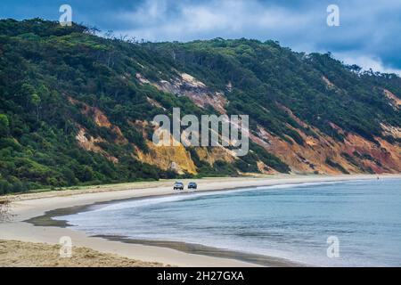 Four-wheel drive travel allong the coloured sand of the eroded sand dune cliffs of Rainbow Beach in the Cooloola Section of the Great Sandy National P Stock Photo