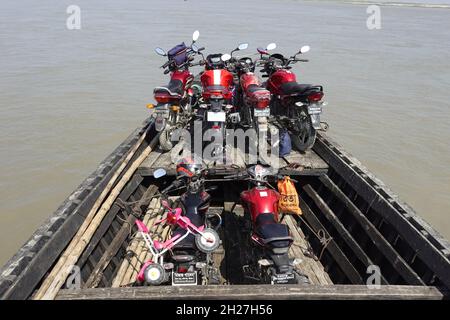 Bangladesh – September 24, 2021: Motorbikes are crossing the river in passenger boats in the rural village area at Rawmari, Kurigram, Bangladesh. Stock Photo