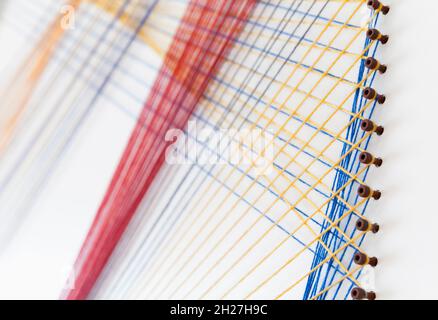 Abstract background photo with colorful treads intersections over white wall, artistic geometric pattern Stock Photo