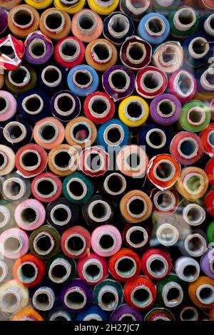 Colorful and multi-colored yarn bundles are patterned in a shop. Round colored yarn bundles texture background. Stock Photo