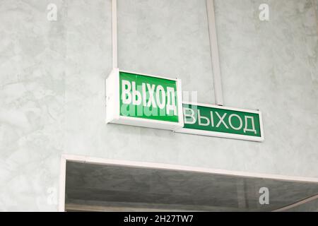 Green sign in Russian exit above the door close up
