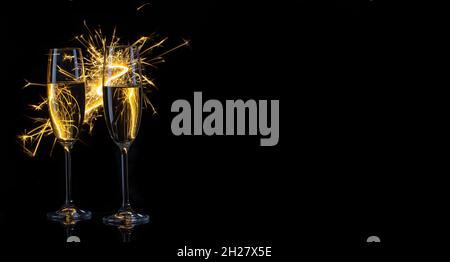 Two glasses of champagne and sparklers on black background Stock Photo