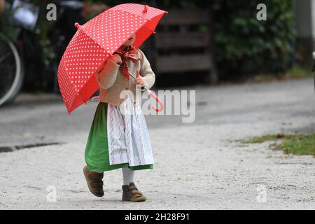 Es regnet - Ein kleines Mädchen in Trachtenkleidung mit Regenschirm - It is raining - A little girl in traditional clothes with an umbrella Stock Photo
