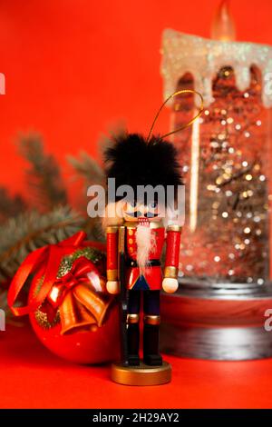 christmas nutcracker figurine with decorations on a red background. Stock Photo