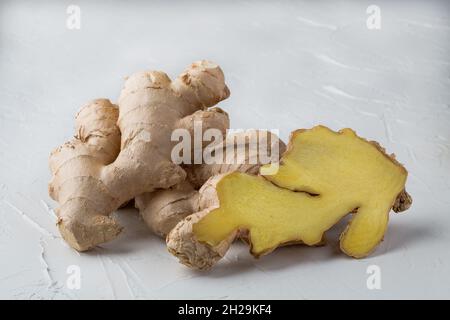 Whole and cut Ginger Root on wood background Stock Photo