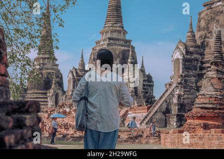 AYUTTHAYA, THAILAND - Feb 08, 2020: A tourist exploring the ancient ruins of Wat Phra Si Sanphet inside Ayutthaya Historical Park