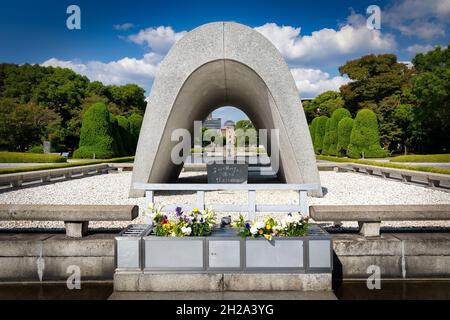 The Hiroshima Victims Memorial Cenotaph with its stone chamber containing the names of over 300,000 victims of the atomic bomb blast at the Peace Memo Stock Photo