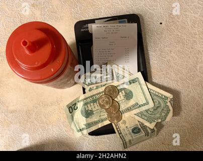 New York, USA. 15th Oct, 2021. The restaurant bill and money is on a table. Tipping has a different meaning in the USA than in Europe. 20 percent is part of good manners not only in restaurants, but also bars, cafes and sometimes even snack bars. Credit: Benno Schwinghammer/dpa/Alamy Live News Stock Photo