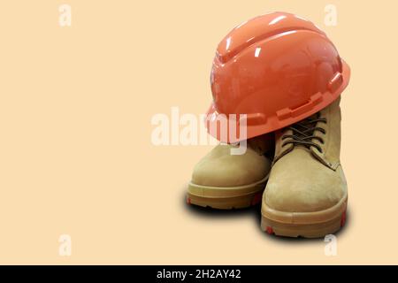 Safety helmets and boots made of leather are equipment that workers must have when working in construction, to protect their feet and heads. Stock Photo
