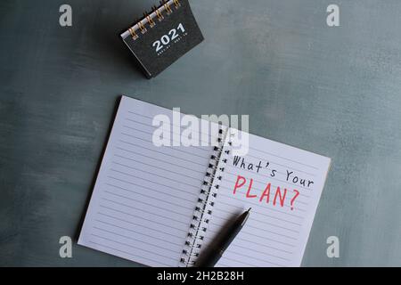 Business strategy concept. Top view of desk calendar and notebook with text WHAT'S YOUR PLAN? Stock Photo