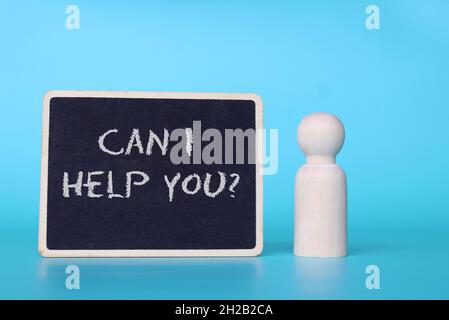 Wooden doll and mini blackboard with text CAN I HELP YOU? Stock Photo