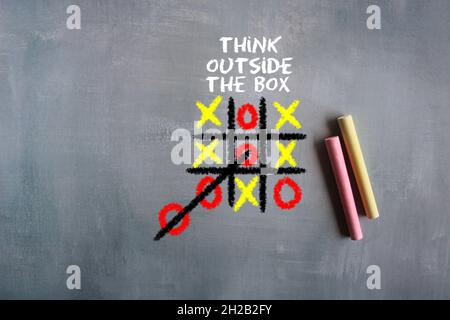 Creative thinking and new ideas concept. Hand drawn Tic-tac-toe game and text THINK OUTSIDE THE BOX. Stock Photo
