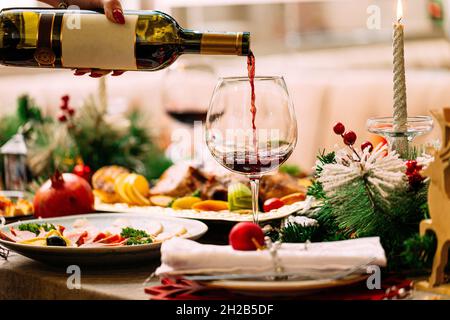 Pouring red wine in a glass on new year table Stock Photo