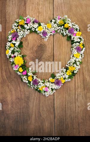 Beautiful heart shaped spring flower wreath. Flowers and leaves used in natural herbal plant medicine to treat a large variety of illnesses. Stock Photo